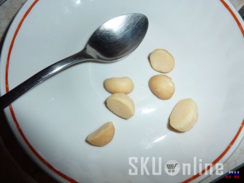 Орехи макадамия на блюдечке с ложечкой